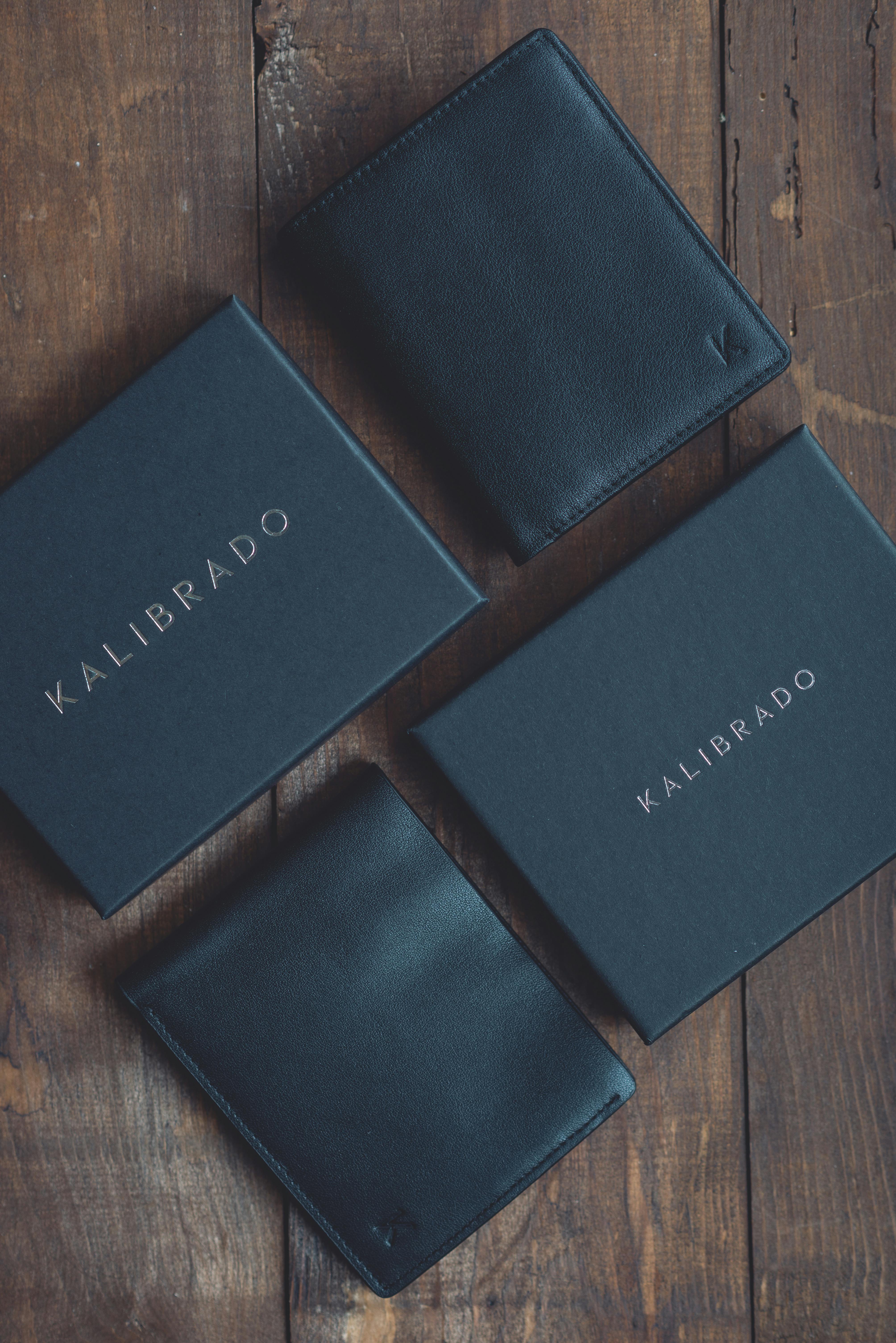 Stylish black leather wallets displayed on a rustic wooden surface, perfect for fashion and lifestyle themes.